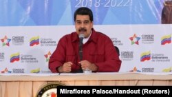 Venezuela's President Nicolas Maduro (C) speaks during a meeting with pro-government governors and mayors, next to Venezuela's National Constitutional Assembly Delcy Rodriguez (L) and Venezuela's Vice President Tareck El Aissami, at Miraflores Palace in Caracas, Dec. 19, 2017.