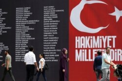 FILE - The names of civilians and police killed while resisting a failed coup attempt are displayed on a banner in Taksim Square, Istanbul, Turkey, July 20, 2016. The slogan reads: 'Sovereignty belongs to the nation.'