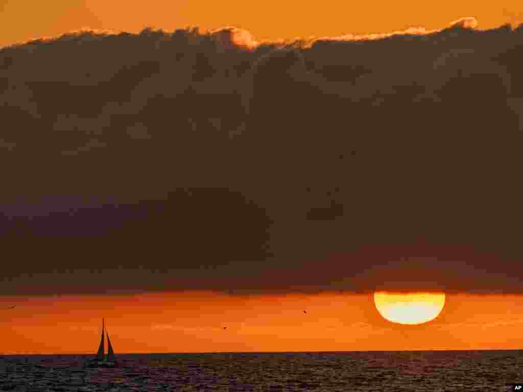 A sailboat glides on the Pacific Ocean off the coast of Venice Beach during sunset in Los Angeles, California, Dec. 27, 2020.