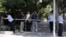 Chinese police officers set up a cordon for journalists outside the gate to the Japanese Embassy ahead of talks between Japan and North Korea in Beijing, Aug. 29, 2012.