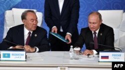 Le président du Kazakhstan, M. Nursultan Nazarbayev, et le président russe, Vladimir Poutine, assistent à la cérémonie de signature du 5e sommet de la mer Caspienne à Aktau, le 12 août 2018.