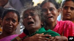 Family members of Raja Ludraswami Harjan, who died after drinking tainted liquor, cry at his funeral in Mumbai, India, June 20, 2015. 