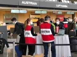Austrians heading home get their papers checked on March 23, 2020 at Dulles Airport.