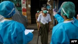 ရန်ကုန်မြို့မှာ ကိုရိုနာဗိုင်းရပ်စ် ကူးစက်မှုရှိမရှိ အိမ်တိုင်ရာရောက် လိုက်လံစစ်ဆေးနေတဲ့ ကျန်းမာရေးဝန်ထမ်းများ။ (မေ ၁၇၊ ၂၀၂၀)