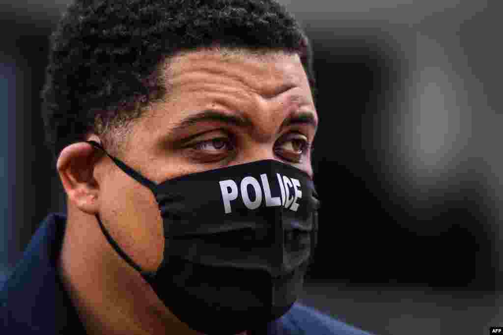 Припадник на полицијата со заштитна маска во Мајами, Флорида (CHANDAN KHANNA / AFP)
