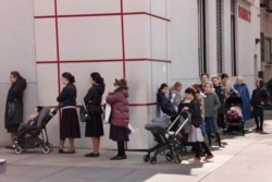 A line of customers waits to enter a pharmacy on the first day of Passover, Wednesday, April 8, 2020 in the Williamsburg neighborhood of New York during the coronavirus pandemic. (AP Photo/Mark Lennihan)