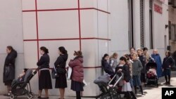 A line of customers waits to enter a pharmacy on the first day of Passover, Wednesday, April 8, 2020 in the Williamsburg neighborhood of New York during the coronavirus pandemic. (AP Photo/Mark Lennihan)