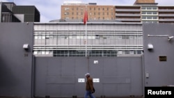 FILE - A man walks past the front gate of the Chinese consulate in Sydney, Australia, July 23, 2015. 