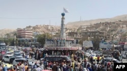 Bendera Taliban dipasang di sekitar alun-alun kota utama di Pul-e-Khumri, 11 Agustus 2021 setelah Taliban merebut kota tersebut, ibu kota provinsi Baghlan sekitar 200 kilometer sebelah utara Kabul. (AFP)