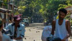 Railway workers, participants of a 'civil disobedience movement' (CDM) against the military takeover of power leave their government provided houses with their belongings as riot policemen watch in Yangon, Myanmar, March 10, 2021.