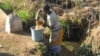 In Malawi, woman in the central district of Dedza gathers water (VOA/L. Masina) 