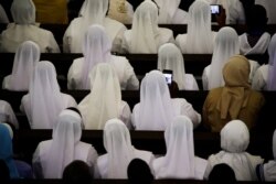 Nuns take photos as Pope Francis presides over a meeting at the Cathedral of the Immaculate Conception, in Maputo, Mozambique, Sept. 5, 2019.