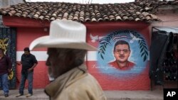 Unos 20 políticos han sido asesinados en Honduras en los últimos meses. Foto: un hombre camina el sábado 27 de noviembre de 2021 frente a un mural del fallecido alcalde Francisco Gaitán en la sede del Partido Liberal en Cantarranas, Honduras. (AP Foto/Moisés Castillo)