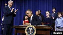 U.S. President Barack Obama signs executive orders on gun violence during an event at the White House in Washington, January 16, 2013. 