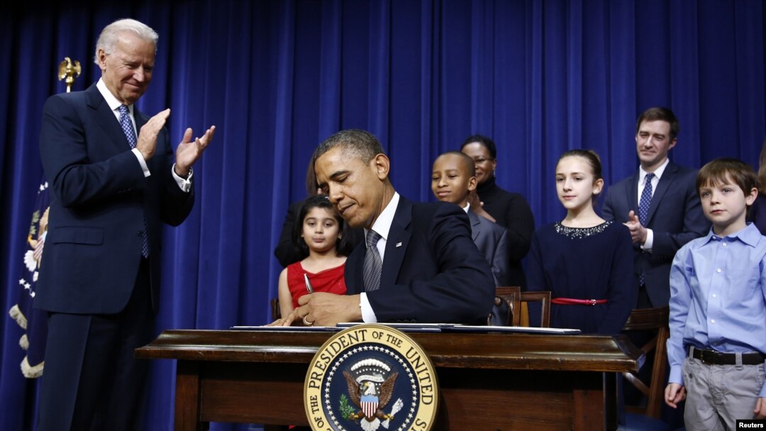 Presiden Obama menandatangani 23 perintah eksekutif untuk memerangi kekerasan senjata api, di Gedung Putih, Washington D.C., disaksikan oleh Wapres Joe Biden dan sebagian dari murid dan keluarga korban penembakan di SD Sandy Hook, Connecticut (16/1).