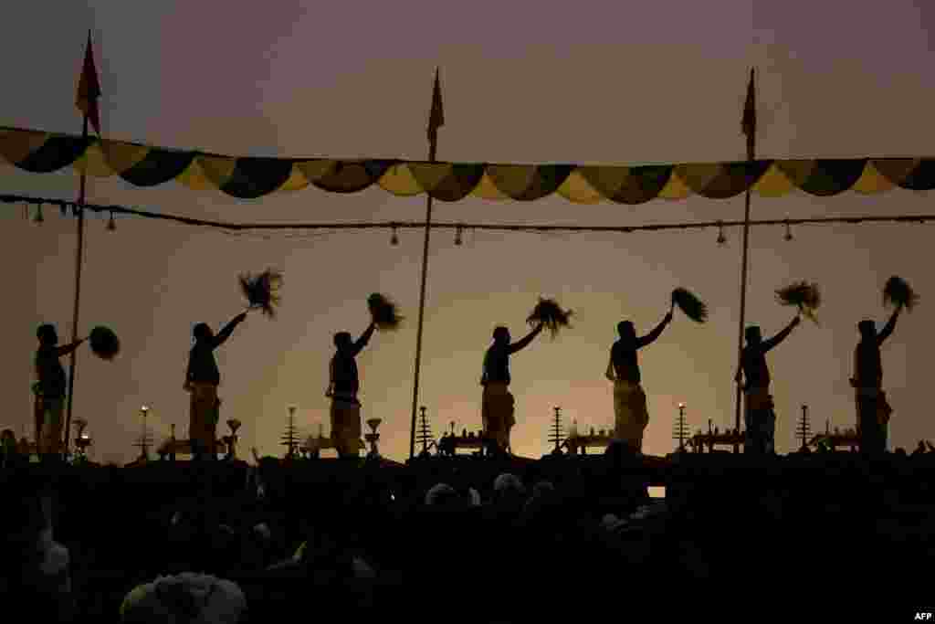 Hindu priests perform prayers on the banks of the Ganges River at Assi Ghat on a foggy winter morning in Varanasi, India.