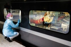 A medical staffer looks through the window of a medicalized TGV high-speed train at the Gare d'Austerlitz train station in Paris, France, before its departure to evacuate patients infected with COVID-19 to other hospitals in the Brittany region.
