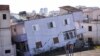 People stand in front of a collapsed building in the town of Durres, western Albania after an earthquake hit.