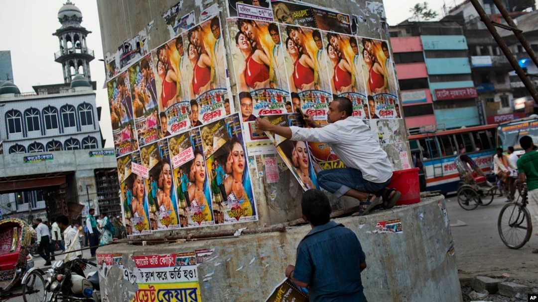 A Bangladeshi man glues movie posters in Dhaka, Bangladesh, Nov. 5, 2015. Fear is running high following months in which four bloggers and three other people have been killed. 