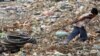 FILE - Young Cambodian boy pulls bicycle tires at Stung Meanchey rubbish dump, Phnom Penh.