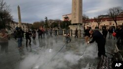 Un travailleur de la municipalité nettoie la chaussée sur le site de l'explosion de mardi dans le quartier historique de Sultanahmet à Istanbul, le 13 janvier 2016.