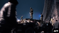 Ukraine -- Maidan self-defence activists stand on an armored vehicle in central Kyiv, February 23, 2014