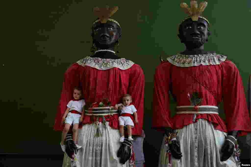 Children pose with two giants during San Fermin festival&#39;s &quot;Comparsa de gigantes y cabezudos&quot; (Parade of the Giants and Big Heads) in Pamplona, Spain.