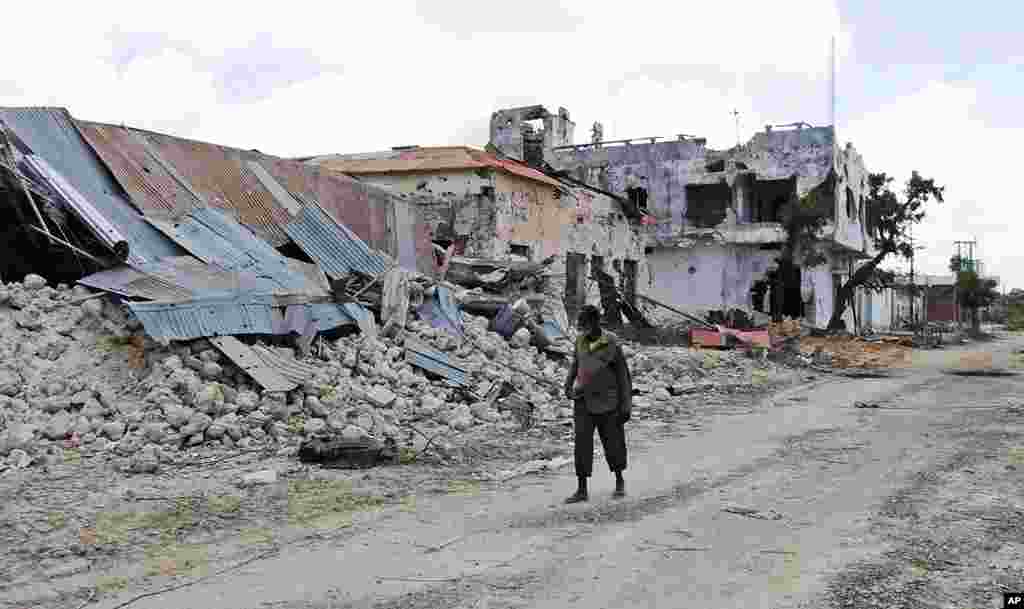 A Somali man walks passed a destroyed building in Mogadishu, Somalia, Aug. 8, 2011. The U.N. refugee agency says it has flown aid to Somalia's capital for the first time in five years as people continue to arrive from famine-hit parts of the country. (AP)