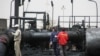 Sudanese workers inspect burnt out oil pipes at the oil-rich border town of Heglig, Sudan, April 24, 2012 (file photo). 