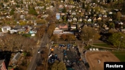 FILE - In an aerial photograph taken with a drone, a group of mostly Venezuelan migrants camp on the tennis courts of a community center after losing access to other shelter in Seattle, Washington, April 3, 2024. 