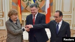 Presiden Ukraina Petro Poroshenko (tengah) berjabat tangan dengan Kanselir Jerman Angela Merkel dan Presiden Perancis Francois Hollande di Kyiv, Ukraina (5/2).