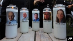 Photos of five journalists adorn candles during a vigil across the street from where they were slain in their newsroom in Annapolis, Md., June 29, 2018.