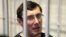 Ukraine's former interior minister Yuri Lutsenko looks out from defendant's cage during a court session in Kiev Feb. 27, 2012