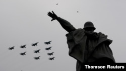 Su-30SM, Su-34 and Su-35S combat aircraft fly in formation above a monument during an air show on Victory Day, which marks the anniversary of the victory over Nazi Germany in World War II, in central Moscow, Russia, May 9, 2020. 