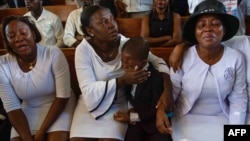 Relatives of Marckendy Natoux, a journalist killed by armed gangs at General Hospital on Dec. 24, 2024, mourn during a funeral service for Natoux in Port-au-Prince, Haiti, Jan. 18, 2025.