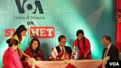 VOA Director David Ensor (center right) along with Myint Myint Win (center left), Managing Director of Sky Net, sign the agreement to broadcast VOA content to Burma. US Ambassador Derek Mitchell (right) looks on.