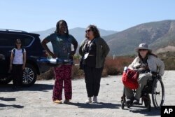 Shirley Jackson, dosen geologi umum York College (kiri), Wilnelly Ventura-Valentin, dan Jennifer Piatek, ahli geologi planetCentral Connecticut State University mengamati drone untuk mensurvei Sesar San Andreas di San Bernadino, California, 26 September 2024. (Ryan Sun/AP)