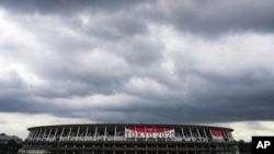 FILE - In this June 23, 2021, file photo, rain clouds move in over National Stadium, in Tokyo. 