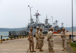 FILE - Sailors stand guard near petrol boats at the Cambodian Ream Naval Base in Sihanoukville, Cambodia, July 26, 2019.