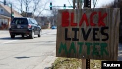 FILE - A Black Lives Matter sign is seen in Evanston, Ill., March 19, 2021. Evanston became the first U.S. city to introduce a reparations program, but some residents denounced the program as insufficient. 