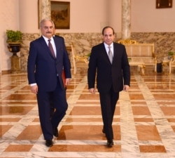 FILE - Libyan military commander Khalifa Haftar walks with Egyptian President Abdel Fattah el-Sissi at the Presidential Palace in Cairo, Apr. 14, 2019 in this handout picture courtesy of the Egyptian Presidency.