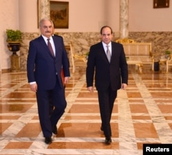 FILE - Libyan military commander Khalifa Haftar walks with Egyptian President Abdel Fattah el-Sissi at the Presidential Palace in Cairo, Apr. 14, 2019 in this handout picture courtesy of the Egyptian Presidency.