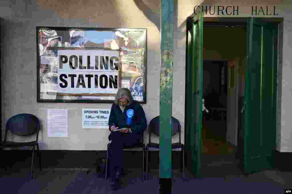A representative of Britain&#39;s Conservative party sits outside a Polling Station in Barnes, south-west London.