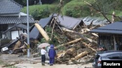 Warga melihat lokasi longsor akibat Topan Lan di Ayabe, prefektur Kyoto, Jepang barat, 15 Agustus 2023. (Foto: Kyodo via REUTERS)