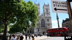 Sebuah bus tingkat merah London melewati tanda tempat pemungutan suara di seberang Westminster Abbey di London saat Inggris mengadakan pemilihan umum, 4 Juli 2024. (Paul ELLIS/AFP)