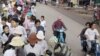 Cambodian garment factory workers wait for the ride in front of their factory to go home in Phnom Penh, Cambodia. 