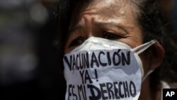 Un manifestante, con una mascarilla que dice "¡Vacunación ya! Es mi derecho, SOS", asiste a una protesta en Caracas exigiendo una distribución más equitativa y rápida de las vacunas, el 17 de abril de 2021.