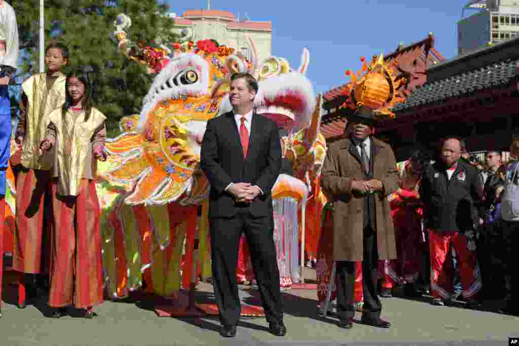 旧金山市市长马克·法雷尔2018年2月16日在旧金山举行的农历新年庆祝活动中聆听。 右边是前市长威利·布朗。鸡年结束，狗年开始。