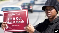 FILE - Shanda Burrell of Charlotte, N.C., holds a sign during a rally by U.S. census advocates at the Mas Jid Ash-Shaheed mosque in Charlotte, aimed at persuading people to fill out the 2010 census form. 