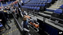 Seorang petugas memberesi bola-bola basket setelah laga bola basket antar universitas NCAA, Atlantic Coast Conference, dibatalkan, Greensboro, N.C., 12 Maret 2020. 